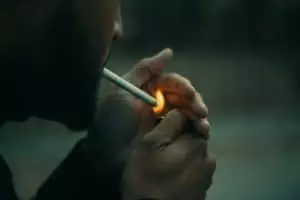 close-up photography of man using cigarette during daytime