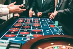 Les tournois de poker en ligne sont-ils les nouveaux sports télévisés ? Group of people playing roulette, placing bets in a casino setting.