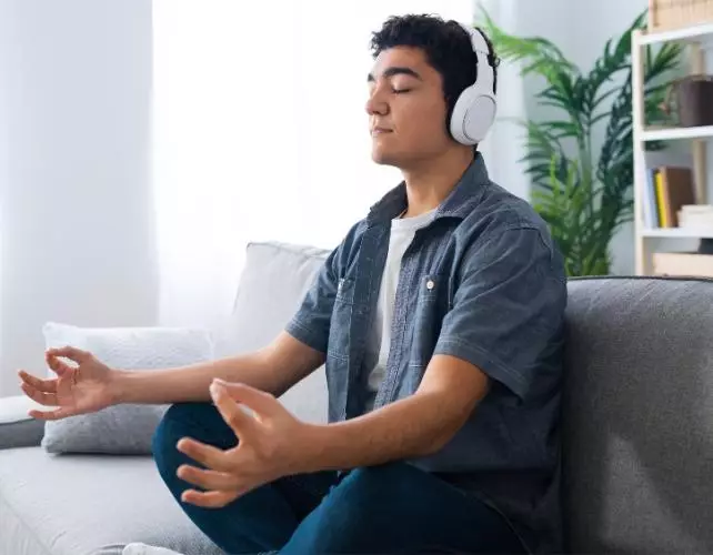 Un homme en pleine méditation sur un canapé