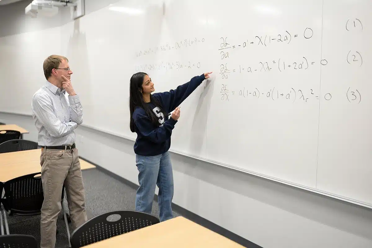 Divya Tyagi, à droite, étudiante en ingénierie à Penn State, présente son travail sur un problème mathématique vieux de cent ans à Sven Schmitz, membre du corps professoral du Collège d'ingénierie et conseiller de Tyagi.