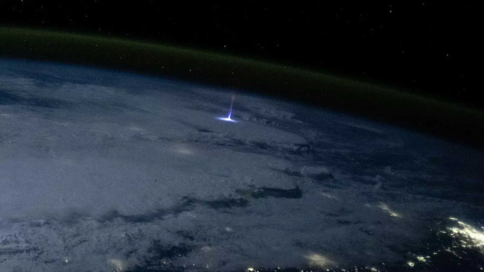 Une photo prise depuis l'espace montrant un immense jet de lumière bleue s'élevant au-dessus d'un orage