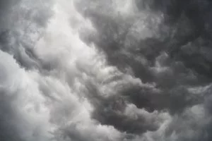 Moody and dramatic storm clouds forming in a turbulent overcast sky.