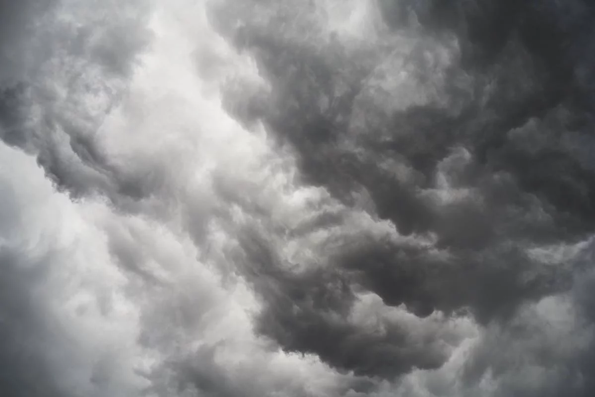 Moody and dramatic storm clouds forming in a turbulent overcast sky.