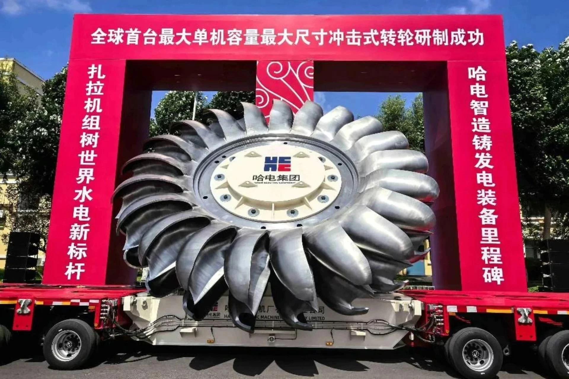 La turbine de Harbin Electric. Et le texte traduit : « Première mondiale et plus grande capacité, turbine à impulsion de plus grand diamètre développée avec succès », « La turbine Zala établit une nouvelle référence mondiale pour l'hydroélectricité ».