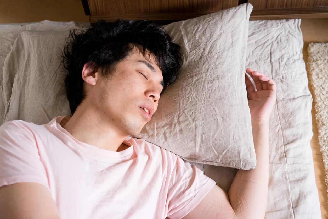 Homme asiatique endormi dans un lit