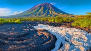 Illustration de l'Ol Doinyo Lengaï, le volcan tanzanien aux coulées de lave passant du noir au blanc.