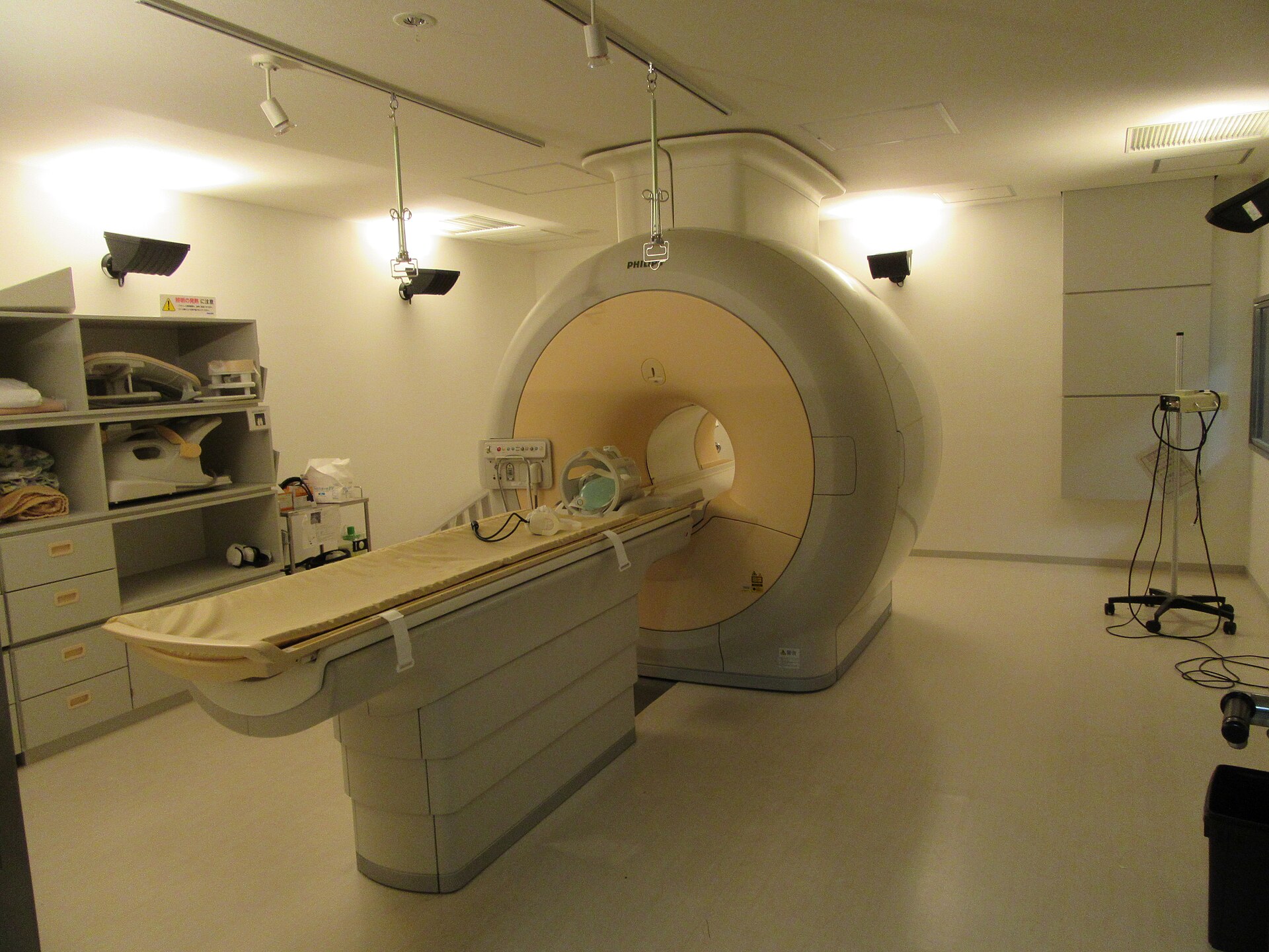 Salle d’imagerie avec un appareil d’IRM et sa table d’examen équipée d’une antenne pour la tête